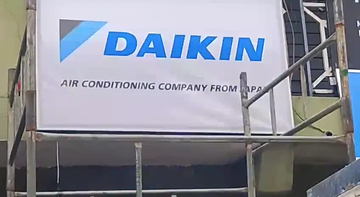 Daikin commercial building sign mounted at first-floor level behind scaffolding in Lagos.
