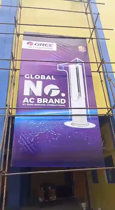 Multi-storey GREE promotional mesh banner secured to exterior building scaffolding in Lagos.